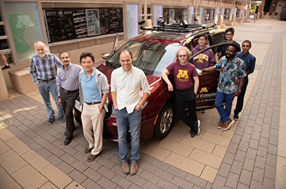 U of M researchers standing around the MnCAV automated vehicle