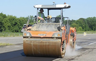 A roller compacting fresh asphalt pavement