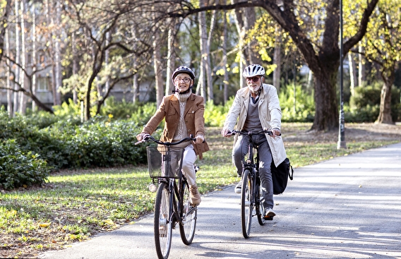 Older couple biking in a city