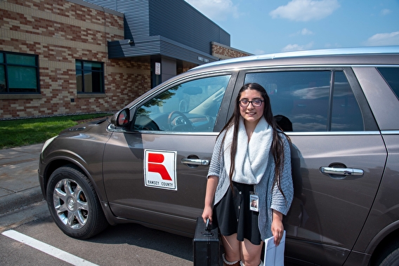 Ramsey County intern Diana Flores Castillo standing in front of a county vehicle