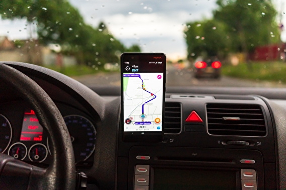 Smartphone mounted on a vehicle dashboard displaying GPS