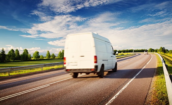 White van driving down rural highway