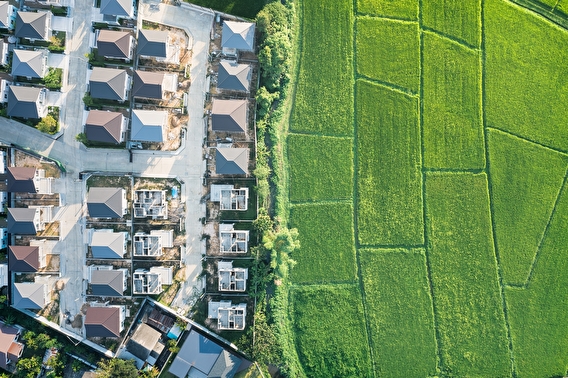 Aerial view of a suburban development bordering green fields