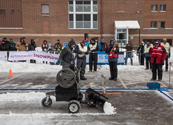 Automated snowplow clears snow from the contest track