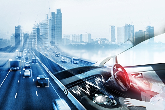 Person sitting in a seat of an automated vehicle with a freeway and city in the distance