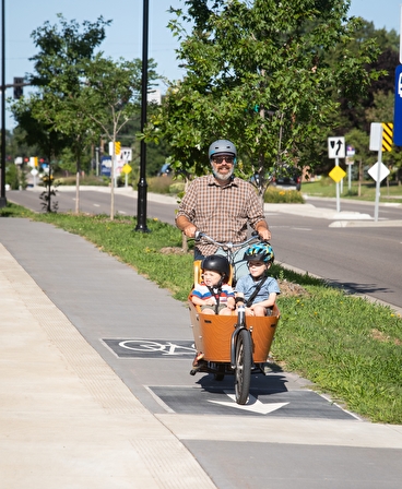 Man biking with children along 66th Street in Richfield, MN