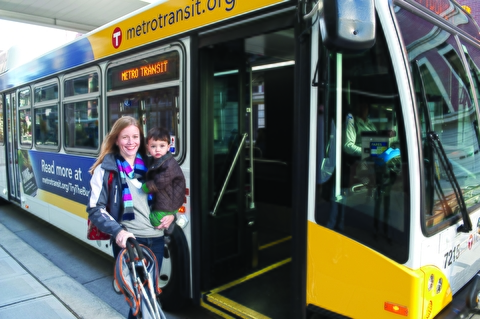 Woman with small child and stroller boarding a bus